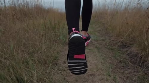 Woman Jogging on Grassy Rural Trail