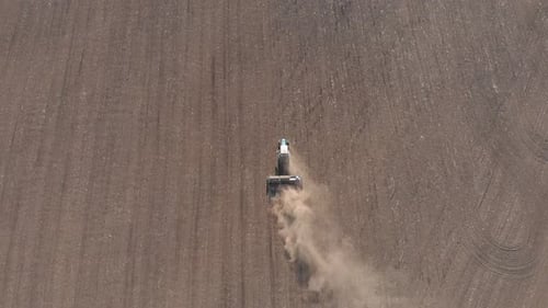 Aerial View Modern Red Tractor on the Agricultural Field on Sunset Time. Tractor Plowing Land and