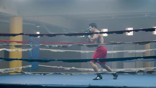 Junger männlicher Boxer beim Schattenkampf beim Training