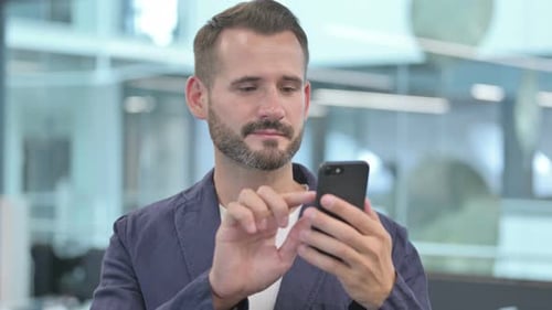 Man Using Smartphone in Modern Office Setting