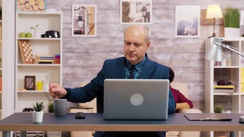 Man Working at Laptop Computer at Home
