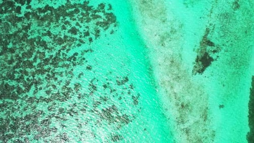 Wide angle birds eye tourism shot of a white sandy paradise beach and blue ocean background
