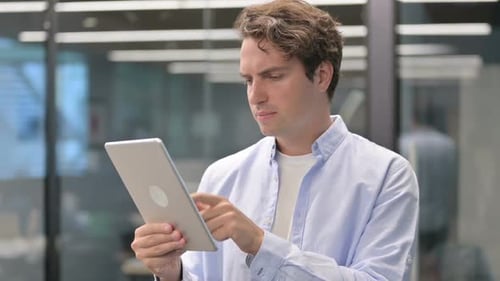 Portrait of Man Having Loss on Tablet in Office