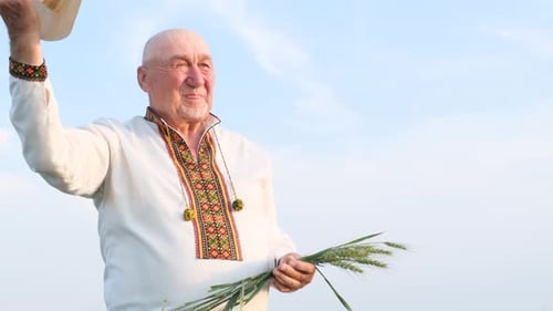Senior Man Holding Wheat in Rural Setting