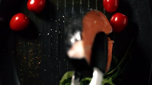 A Salmon Fillets is Puting Over on the Grill Pan with Tongs