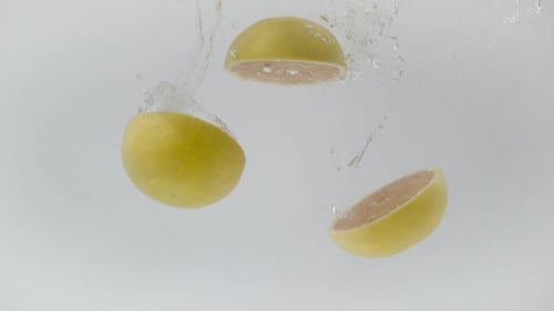 Pomelo Slices Plunging into Fresh Water