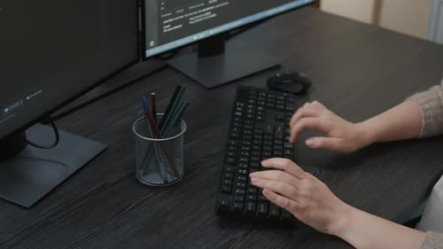 Hands Typing on Keyboard in Office Environment