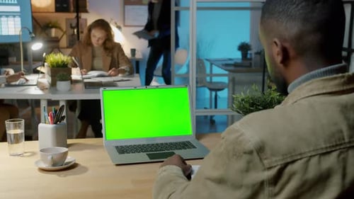 Over the Shoulder Shot of African American Businessman Looking at Laptop with Chroma Key Green