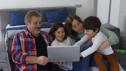 Happy Family Using Laptop Together at Home