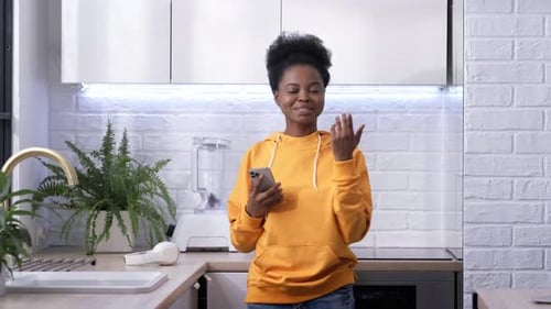 Woman Dancing in Kitchen with Smartphone