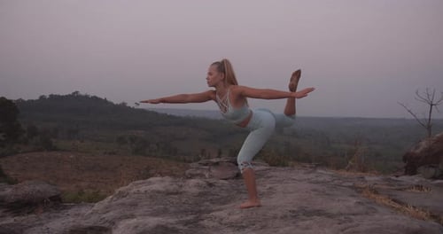 Side View of Female Model Arms Stretched Out Doing Yoga By the Mountains