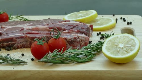 Raw Steak with Fresh Herbs and Vegetables Close Up