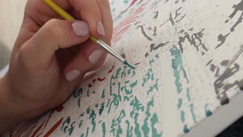 Woman Paints Canvas Using Numbered Paint By Numbers