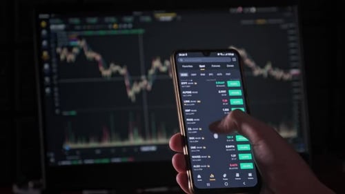 Hand Scrolls Through Crypto Stock Data on Phone