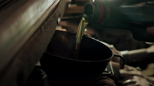Close Up Shot of Pours Oil Into the Engine in Maintenance Car Garage