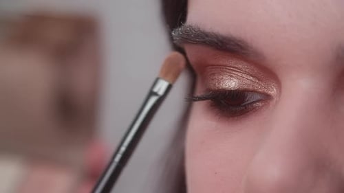 Professional Makeup Artist Doing Smoky Eyes Effect with Liner and Eye Shadow