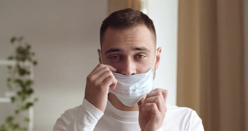 Young Adult Putting on Protective Surgical Mask