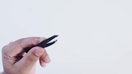 Hand Holding Black Tweezers Close Up
