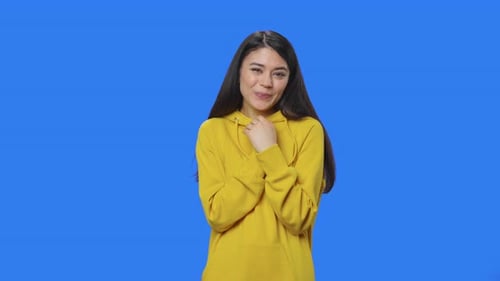 Woman Smiling and Gesturing in Yellow Hoodie