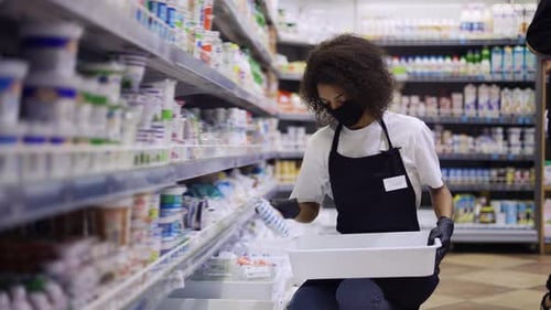 Female Worker Arranging Products on Shelves in Milk Department in Supermarket Slow Motion
