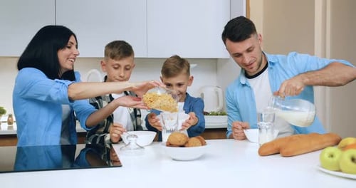 Family of Four Enjoys Breakfast at Kitchen Table