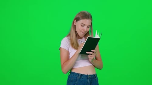 Woman Writing in Notebook on Green Screen