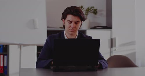 Businessman Completing Deadline in Office
