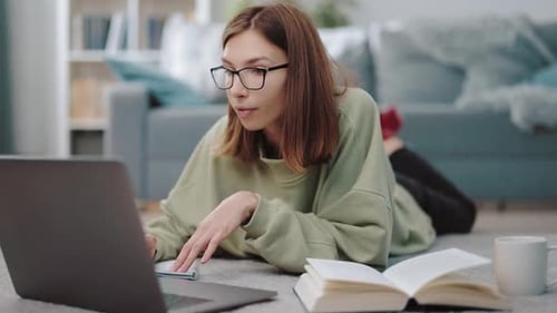 Woman Studying at Home with Laptop and Notebook