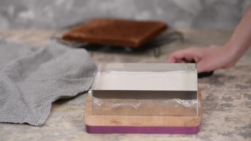 Person Making Chocolate Cake in Metal Mold