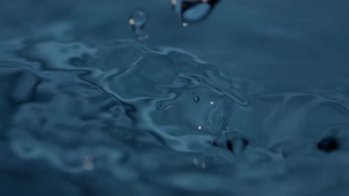 Water Droplets Splashing into a Blue Pool