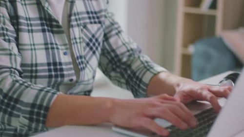 Young Adult Types on Laptop at Desk