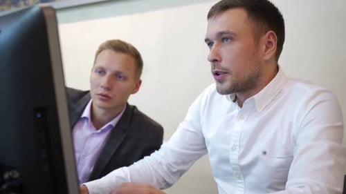 Men Working Together at Computer in Office