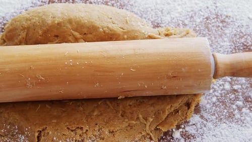 Dough Being Flattened With a Rolling Pin