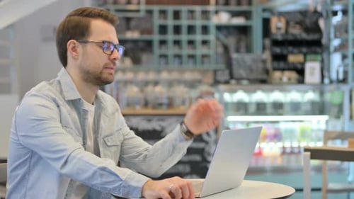 Stylish Man Working on Laptop in Coffee Shop