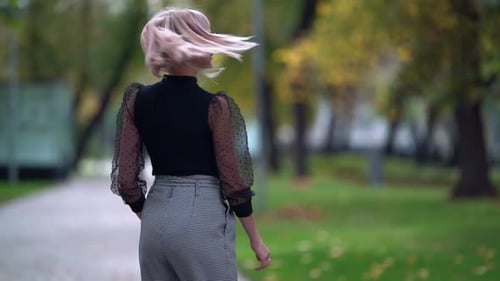 Charming Blonde Woman Is Walking in Fall Park and Posing, Cheerful and Positive Townswoman