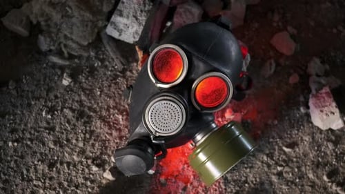 Nahaufnahme: Gasmaske blinkt rot und liegt in einem verlassenen Gebäude zwischen Betontrümmern und Wänden