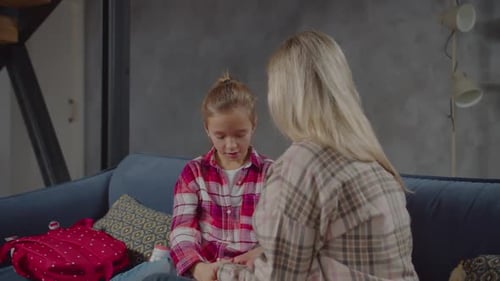 Adult Comforts Crying Child on Couch Indoors