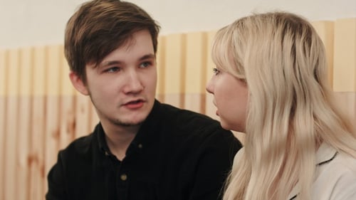 Portrait of young couple talking seriously and drinking