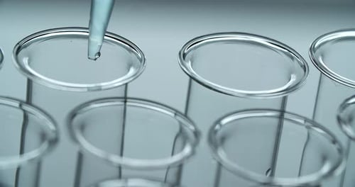 Clear Liquid Dripping into Glass Test Tubes