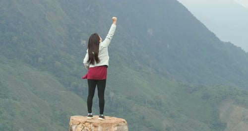Woman Standing on Rock Celebrating Mountain View