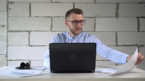 Businessman analyzes business charts while sitting in the office at a laptop