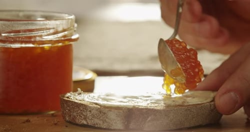 Caviar Being Placed on a Bread Slice