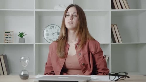 Woman Stretching at Desk in Office Setting