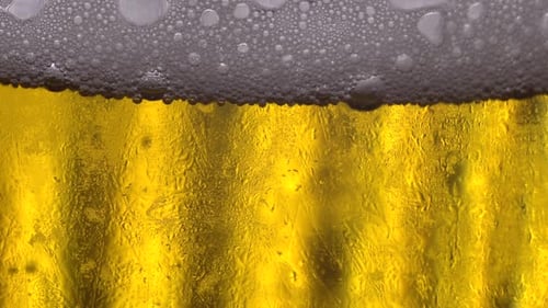 Refreshing Cold Beer with Frothy Bubbles and Condensation
