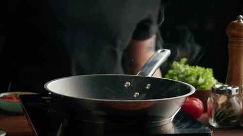 Person cooking meat in frying pan