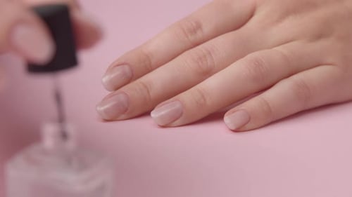 Closeup Woman Hand on Pink Makes Manicure for Herself