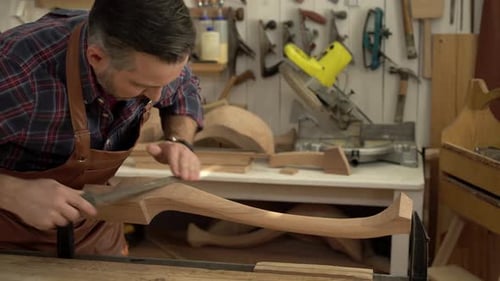 Cabinet Maker Polishes Cabrioli Leg in his Workshop