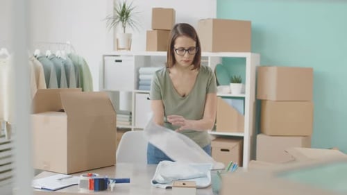 Saleswoman Preparing Ordered Good for Online Customer