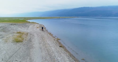 Adult Walking Dog on Lake Beach