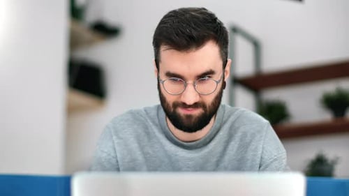 Man With Beard Works at Laptop in Home